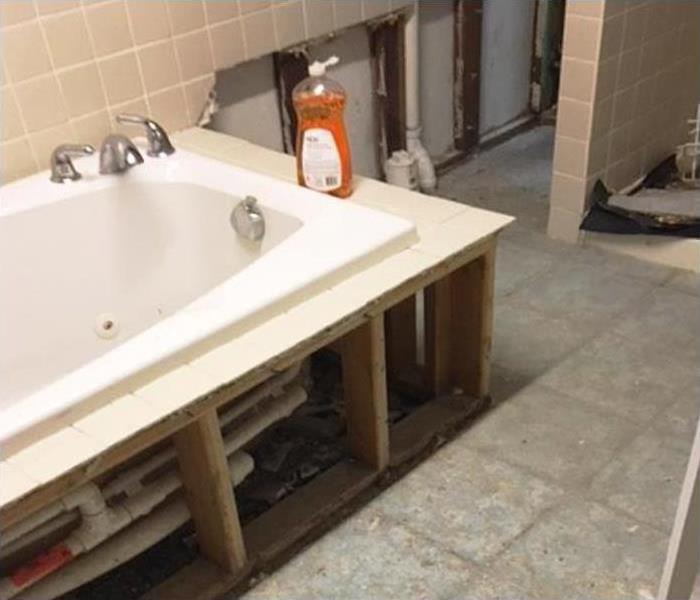 water damage to bathroom floor and tub