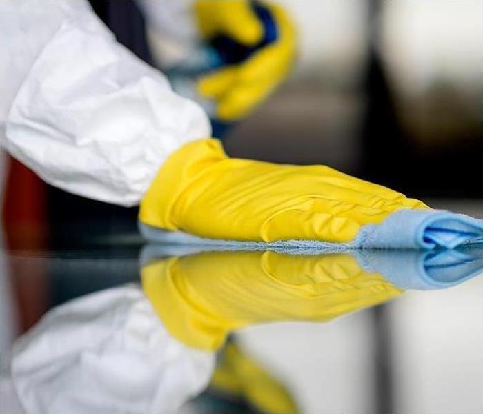 cleaning and sanitizing services for businesses and homes; image of gloved hand wiping surface